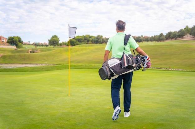 save strokes, 12 Best Golf Bags, golfer, walking, with, bag, on, green